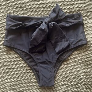 New. Black, high-waisted bikini bottoms with front tie. Size small. Never worn